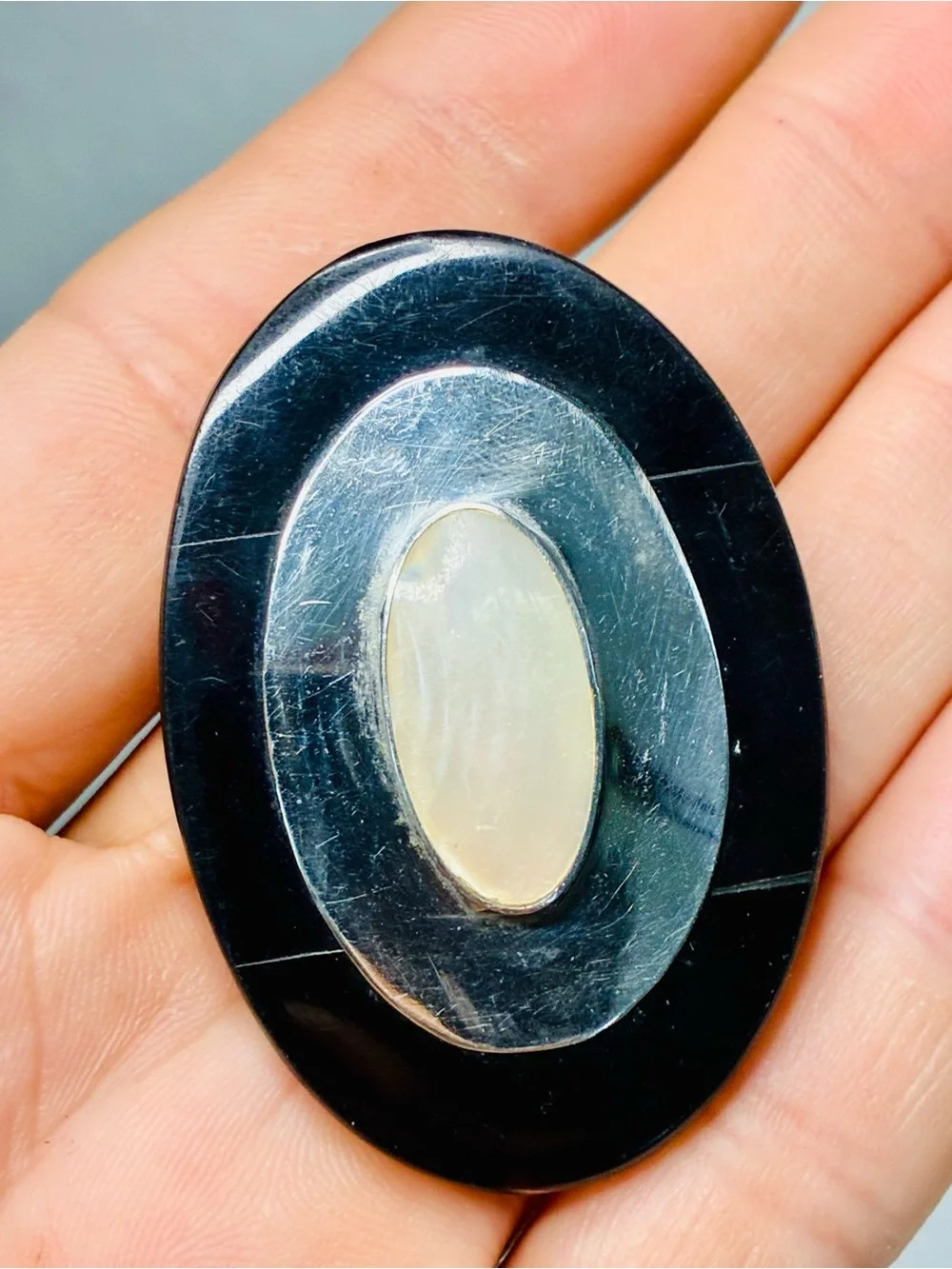 Elevated Simple Black and Silver Oval Brooch with Mother-of-Pearl Center Pendant